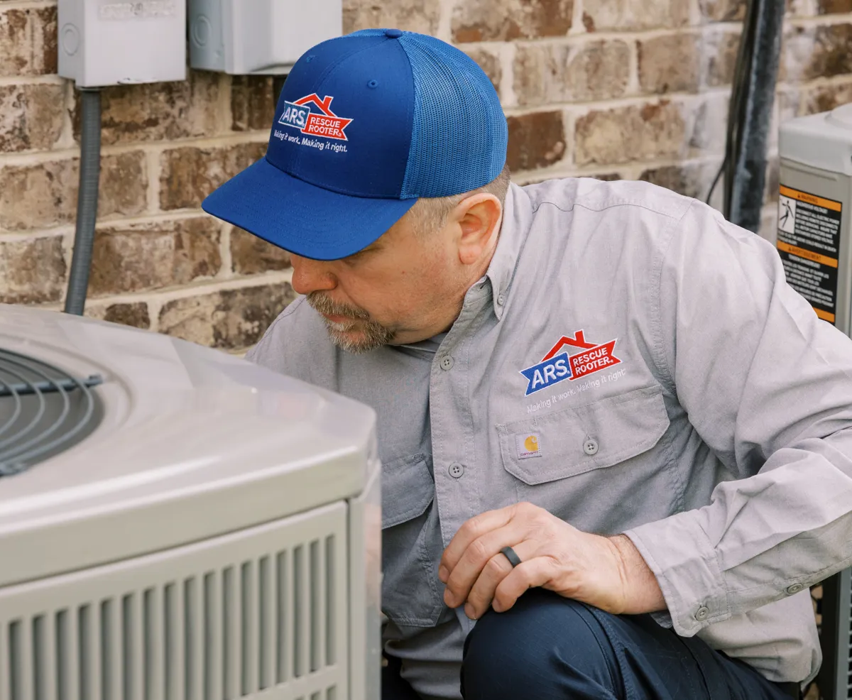ARS Rescue Rooter technician outside of home installing and testing a new AC unit. 