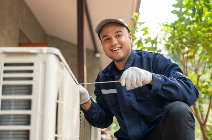 A contractor working on an HVAC unit as part of a comprehensive HVAC Guide for Homeowners.