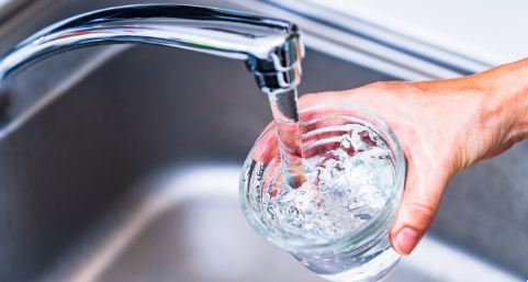 Clean drinking water coming out of the kitchen faucet after water filtration system installation.