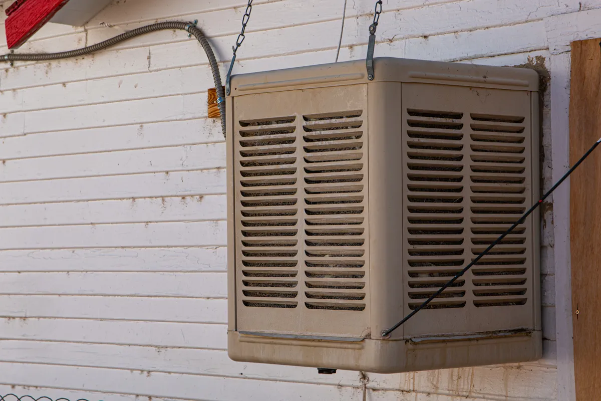 Exterior wall-mounted swamp cooler system installed on a residential building in a dry climate.