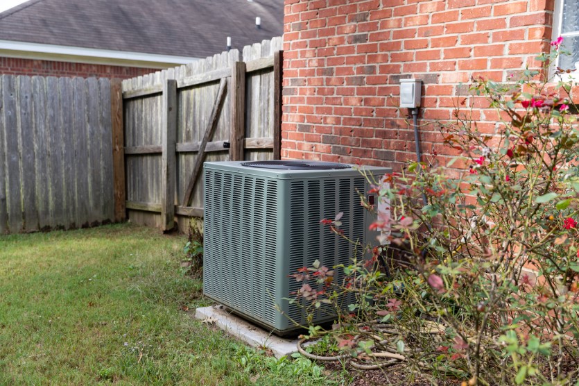 Gray, AC equipment in the backyard of a home.