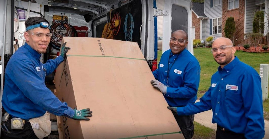 ARS/Rescue Rooter HVAC technicians unloading a new air conditioning unit for professional AC replacement installation at a residential home.